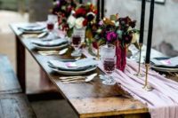 an uncovered table is softened with a pink table runner and spruced up with gold candle holder