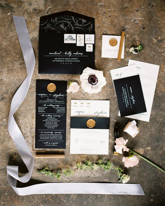 black and white wedding stationery with calligraphy and gold seals for an elegant feel