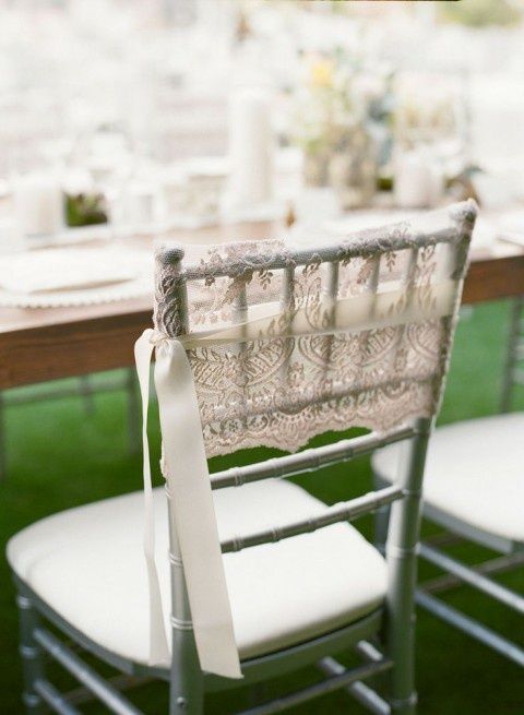 delicate and elegant lace chair cover with a white ribbon is a chic idea for a vintage wedding or an elegant and formal one