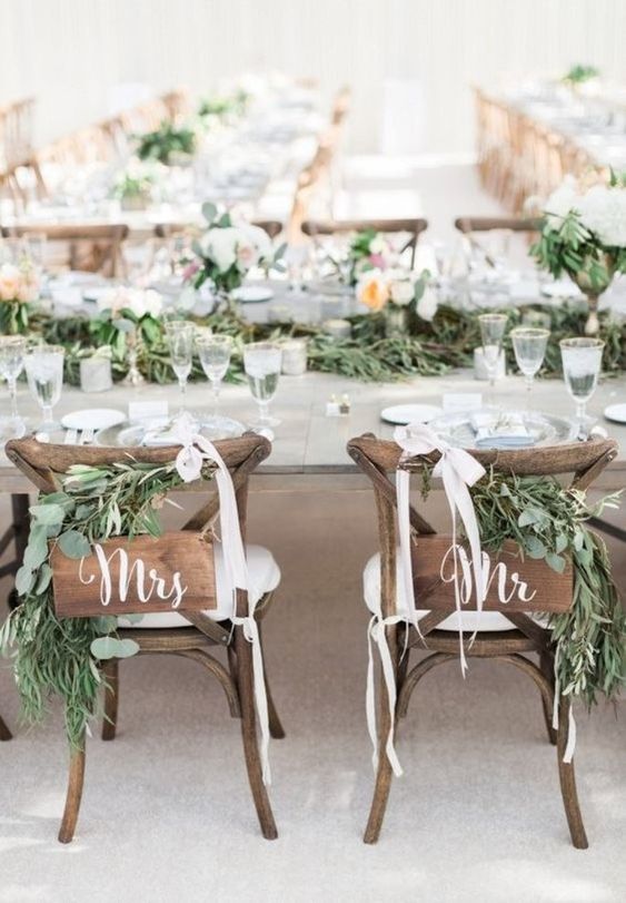 greenery, wooden plaques, white ribbon bows for chic and stylish wedding chair decor with a strong rustic feel