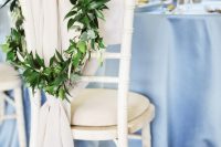 neutral fabric and a greenery wreath are great to decorate a wedding reception chair or a wedding ceremony chair