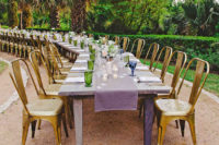 purple and gold seating plus green and blue mismatched goblets made this curving reception table