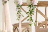 stained chairs with neutral fabric ribbons, greenery, neutral and blush roses are adorable to accent your wedding space