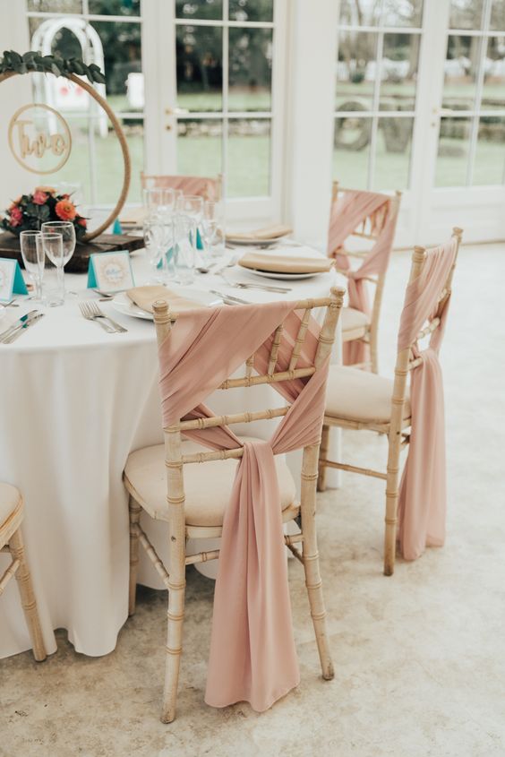 stylish chair decor with pink fabric will give the chairs an elegant and chic feel, and your wedding reception space will look more formal