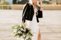 the bride rocking a white minimalist wedding dress, white strappy shoes and a black leather jacket