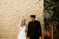 the groom in a total black outfit, the bride wearing a total white outfit with a minimalist feel