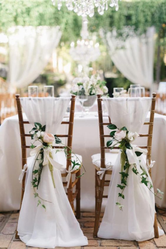white chair covers with neutral and pink blooms and greenery are a timeless idea for a garden wedding, a spring or summer one