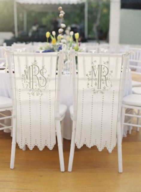white monogrammed and embellished chair covers are a great idea for wedding chair decor, for the couple