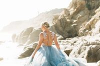 a beautiful coastal wedding dress with a white lace bodice and an illusion back, a blue layered skirt with a train is a chic idea
