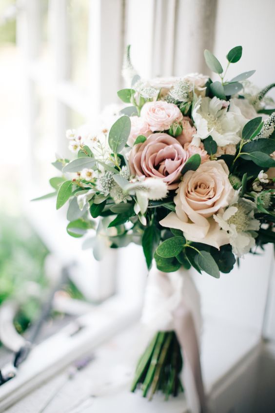 a blush, dusty pink and white rose bouquet with greenery for a spring wedding