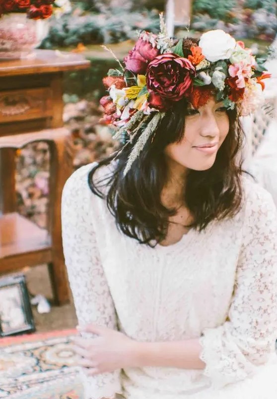 a bold and oversized floral crown with white, orange, fuchsia blooms, grasses and greenery for a spring or summer boho bride