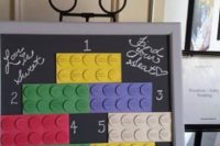 a bright Lego wedding seating chart with colorful Lego elements on the chalkboard