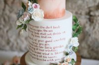 a bright wedding cake with a copper watercolor tier, a white tier and a copper love letter, with sugar blooms and greenery