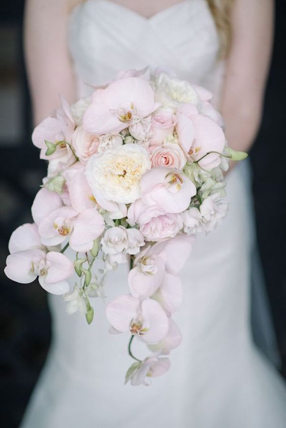 a cascading bouquet with blush orchids and white peonies looks luxurious, chic and romantic
