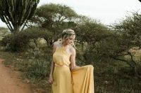 a chic pale yellow A-line wedding dress with a halter neckline and a train for a boho or desert wedding