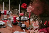 a chic wedding tablescape with pink and red roses and peonies, red and white candles, neutral plates and napkins