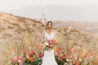 a colorful bright wedding altar of bold blooms, grasses and greenery for a desert wedding