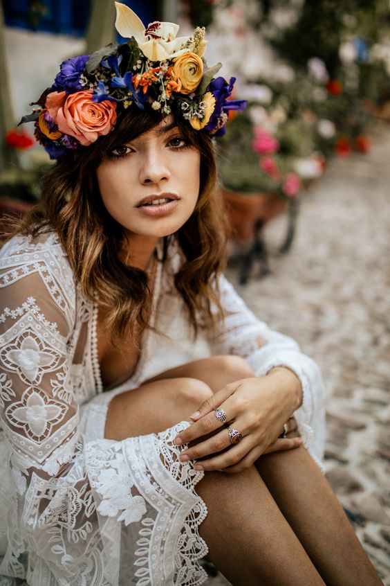 a colorful flower crown with pink, blue, purple, yellow blooms and berries is a bright and fun idea for a summer boho bride