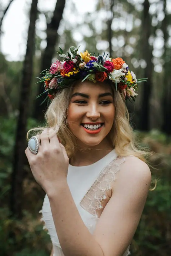 a colorful flower crown with pink, white, yellow, red and blue blooms, berries, greenery and thistles is a lovely idea for summer