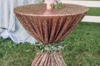 a copper tablecloth with a greenery wrap, bold blooms in a gold vase will add glam to the wedding cocktail space