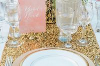 a gold glitter wedding table runner, gold chargers and gold rimmed plates plus a gold vase are lovely for a modern glam wedding