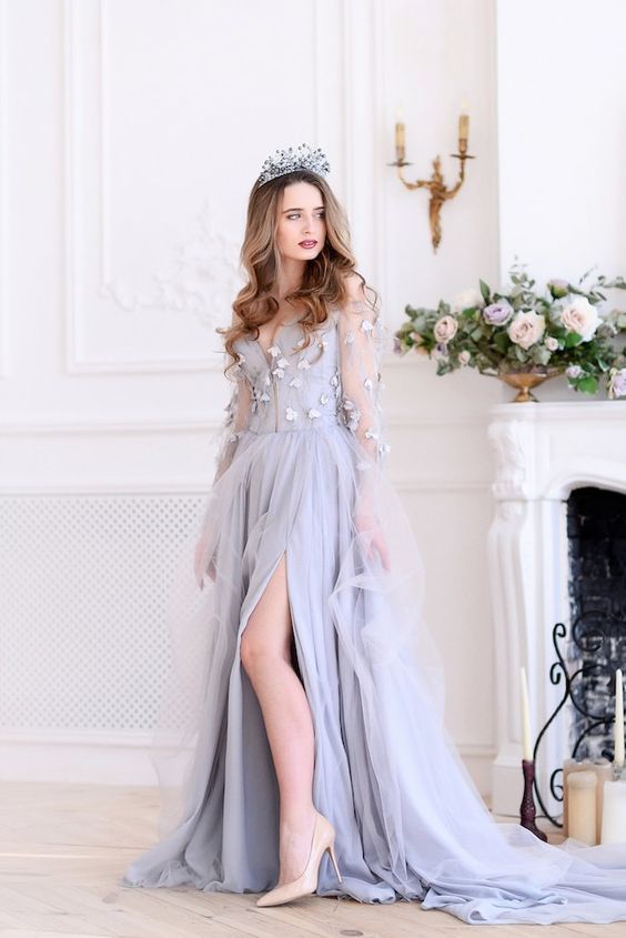 a gorgeois lilac wedding dress with a corset bodice with appliques, illusion sleeves, a layered skirt with a slit and a train