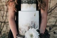 a gorgeous moody wedding cake with watercolor dark florals, sugar blooms and leaves and a black lace top