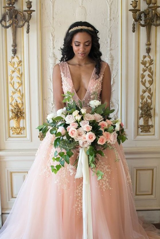 a gorgeous pink princess style wedding dress with a plunging neckline, beading and white floral lace appliques