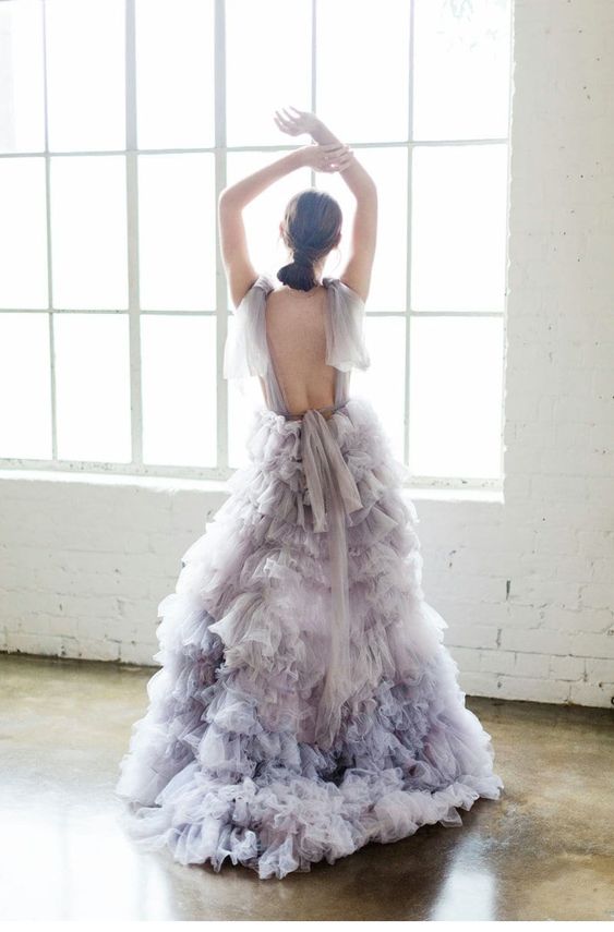 a lilac wedding dress with an open back, bows on the shoulders, a tulel tiered maxi skirt with a train is a refined idea