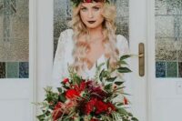 a lush cascading Christmas wedding bouquet with greenery and red blooms is Christmas classics