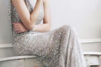 a maxi silver glitter wedding dress with a high neckline and no sleeves, statement earrings and nude heels for a gorgeous glam look