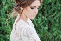 a messy textural updo with a dimensional braided halo and locks down is a great boho hairstyle