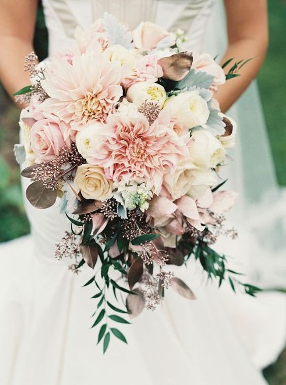 a pastel pink wedding bouquet with dahlias, roses and dark leaves to make a contrast