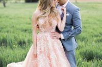 a pink sleeveless wedding dress with a trendy plunging neckline and pearl floral embroidery all over the gown