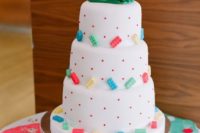 a playful wedding cake in white, with colorful Legos and creative cake toppers
