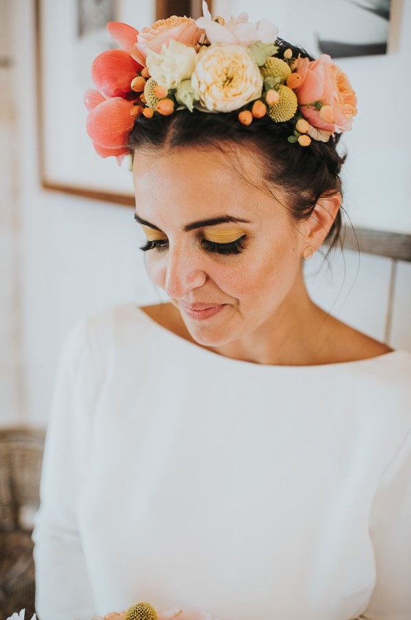 a pretty and bright oversized flower crown with neutral, pink and orange blooms, billy balls and berries is a very cool idea for a summer bride
