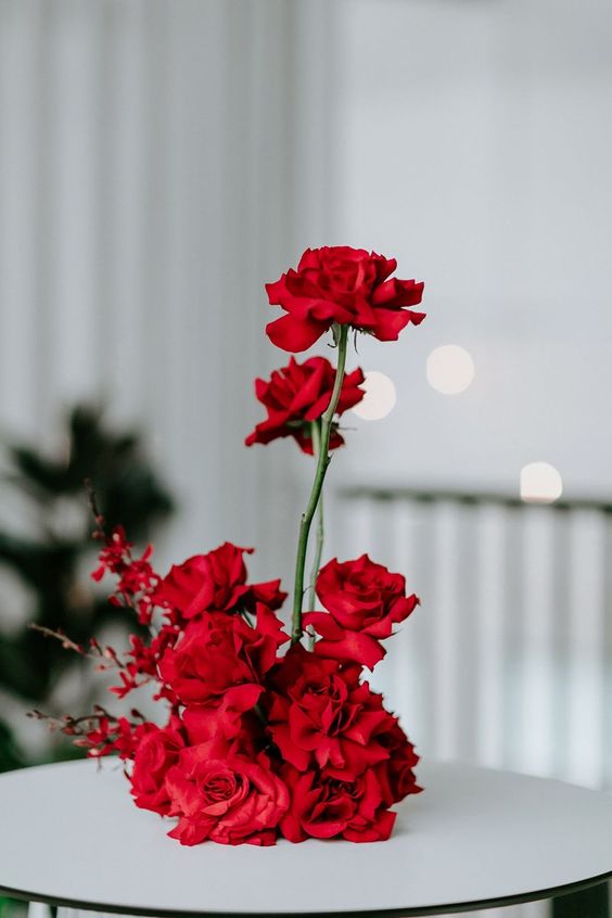a red rose wedding centerpiece is a gorgeous and bold statement for a winter wedding, it a bright color statement