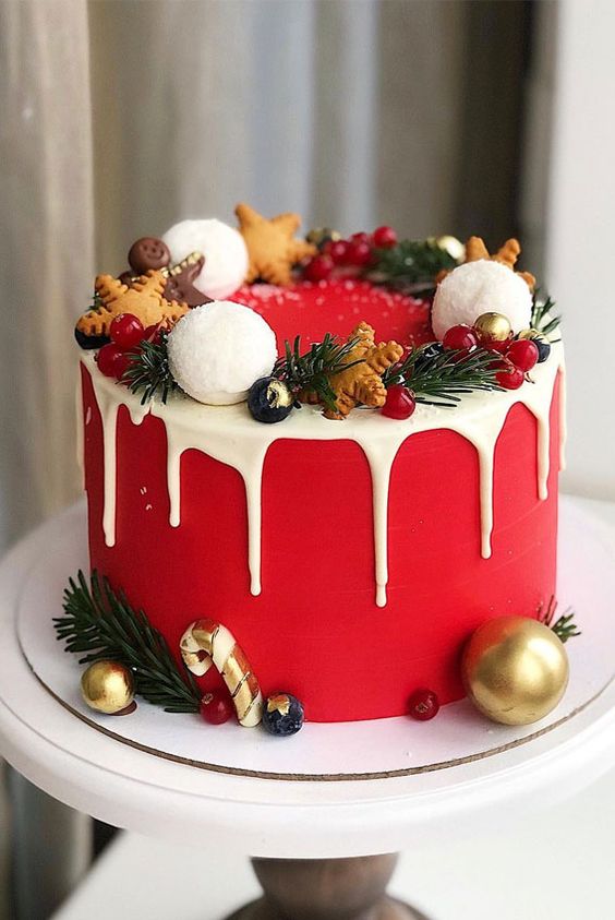 a red wedding cake with creamy drip, gingerbread cookies, ornaments, evergreens and berries is a lovely idea for a winter celebration