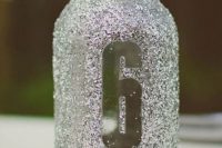 a silver glitter jar with a table number can be used as a vase and can be easily DIYed to make the table look bolder