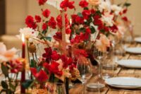 a sophisticated wedding tablescape with red and blush roses and matching candles is a great idea for a winter wedding