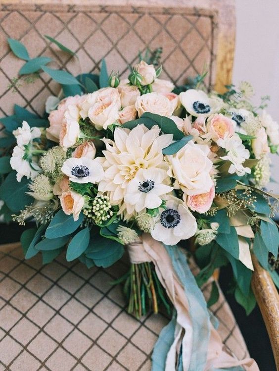 a tender peachy wedding bouquet with some neutral blooms and lots of greenery for texture