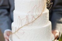 a three tier white lace wedding cake with gold leaf detail is a simple and elegant option for your big day