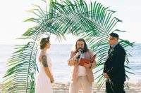 a tropical wedding arch of giant fronds is a cool idea for any kind of tropical or beach wedding