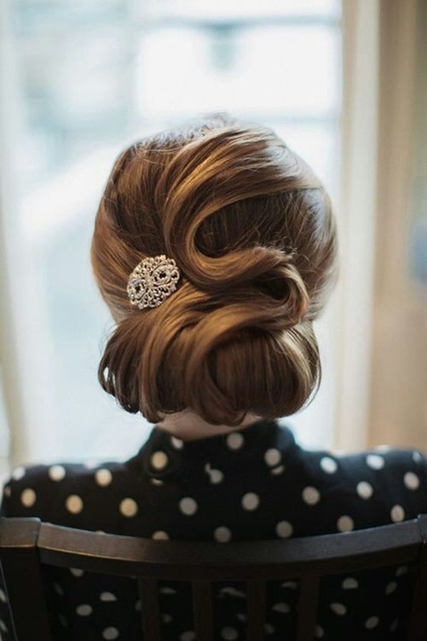 a vintage inspired curled low updo with a shiny hairpiece and fixed waves is a great fit for a retro bride