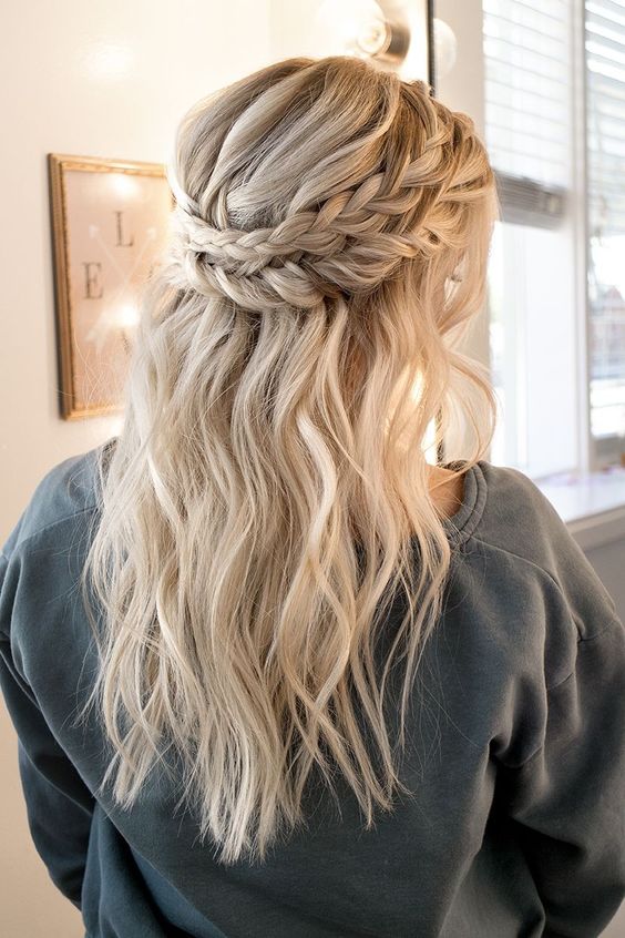 a wavy texturla half updo with a double braided halo and a bump for a boho bride
