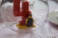 a wedding decoration of a bright Lego table number, a figurine and a tealight on top is a cool DIY