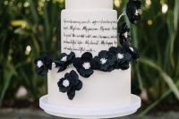 a white buttercream wedding cake with a love letter tier and black sugar blooms is an eye-catchy solution for a black and white wedding