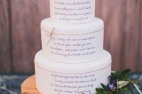 a white buttercream wedding cake with twine, love letters on each tier, greenery, succulents and some blooms