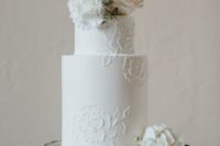 a white floral lace wedding cake with fresh blooms in blush and white is a timeless piece for any wedding