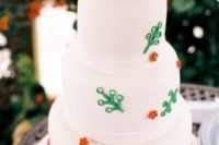 a white wedding cake with colorful Legos, bright touches and Lego figurines on top